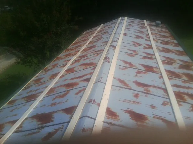 Rusted metal roof panels with new wood purlins before replacement — Storm Damage Roof Repair in Lacona by Roofing Brothers